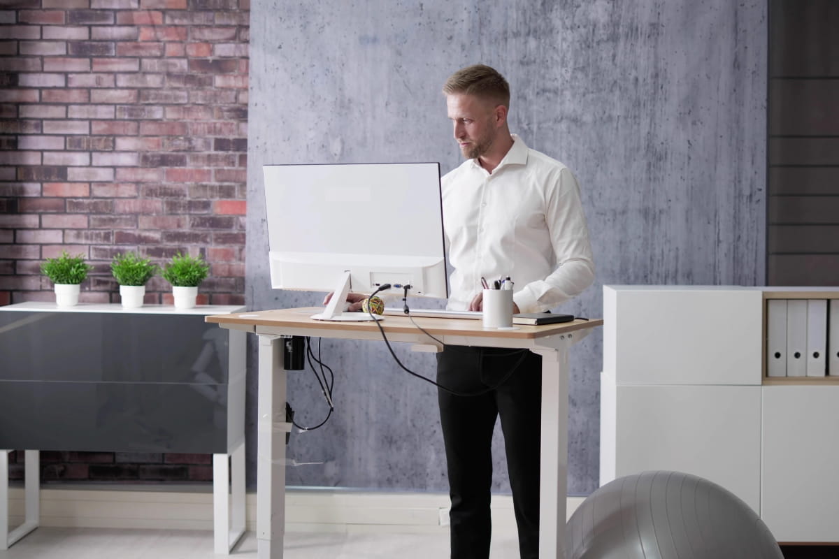 Is Standing Better Than Sitting? Finding the Right Balance at Work 4 Standing workstation setup with monitor, desk accessories and office storage.