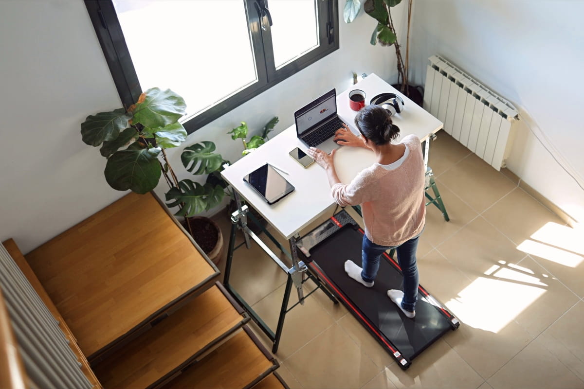 Home office with a treadmill desk setup for alternating movement and computer work.