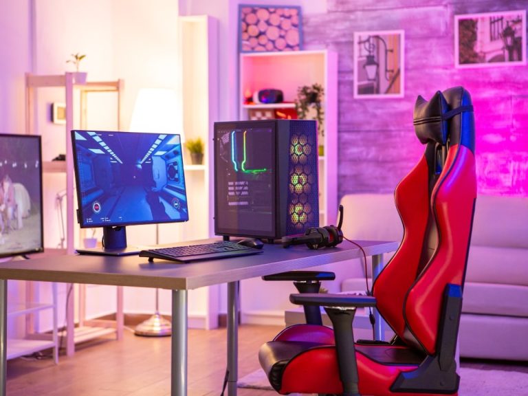 Gaming chair vs office chair? PC desk set up with black and red gaming chair.