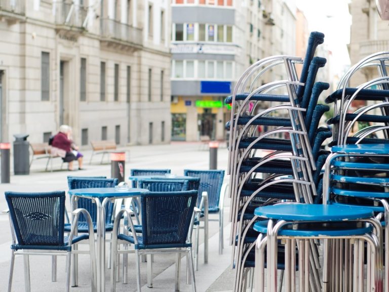 Outdoor cafe with blue stackable chairs.