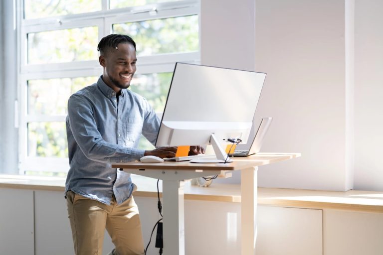 Worker using standing desk ergonomics to support a comfortable office setup.