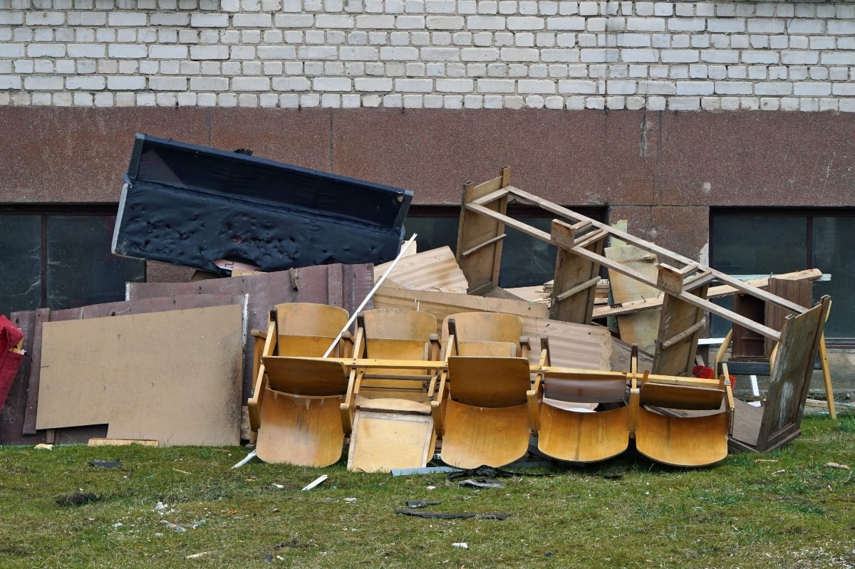 A rubbish pile of broken and wooden furniture. 