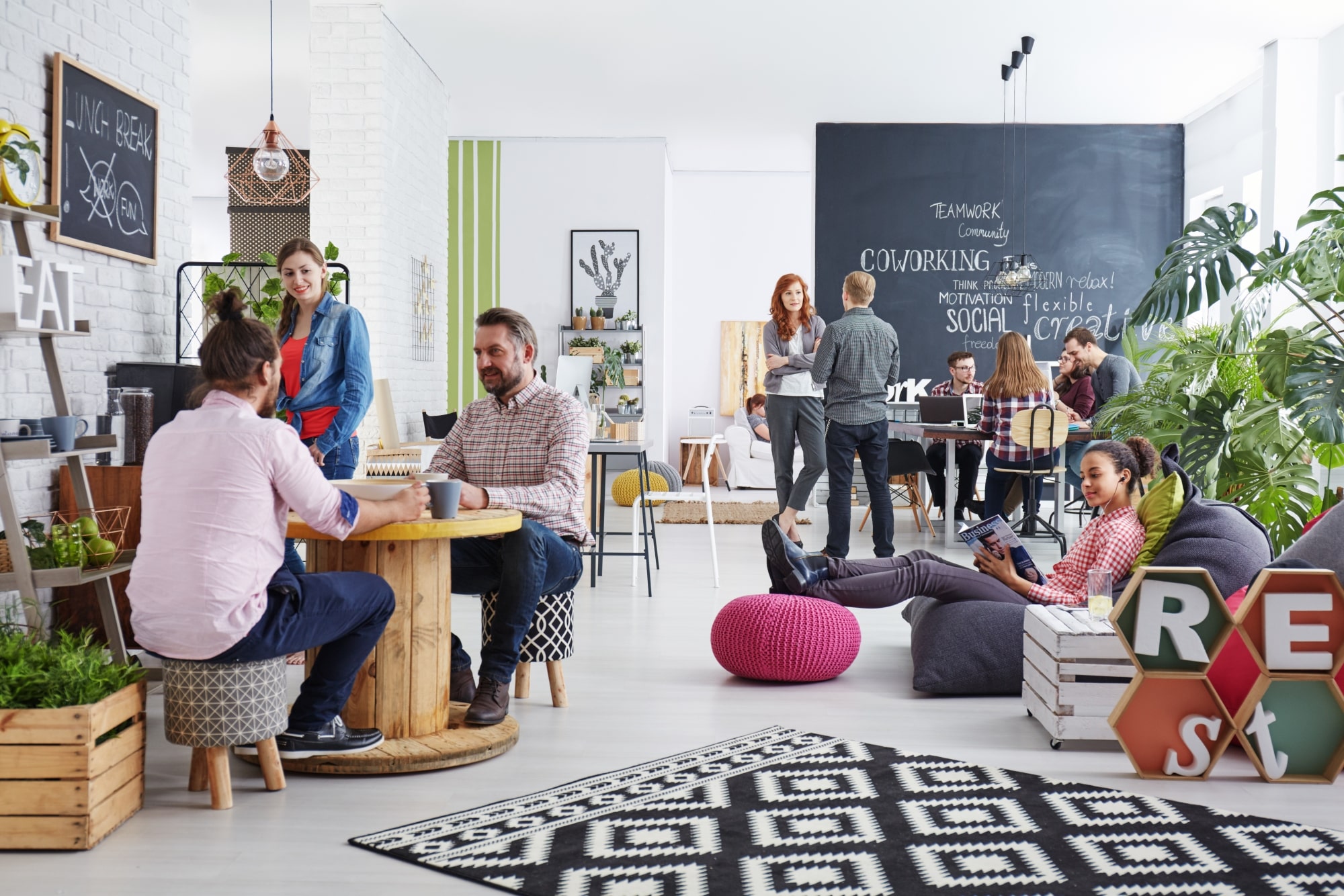 Workers relaxing in a shared recreation zone is a funky coworking office.