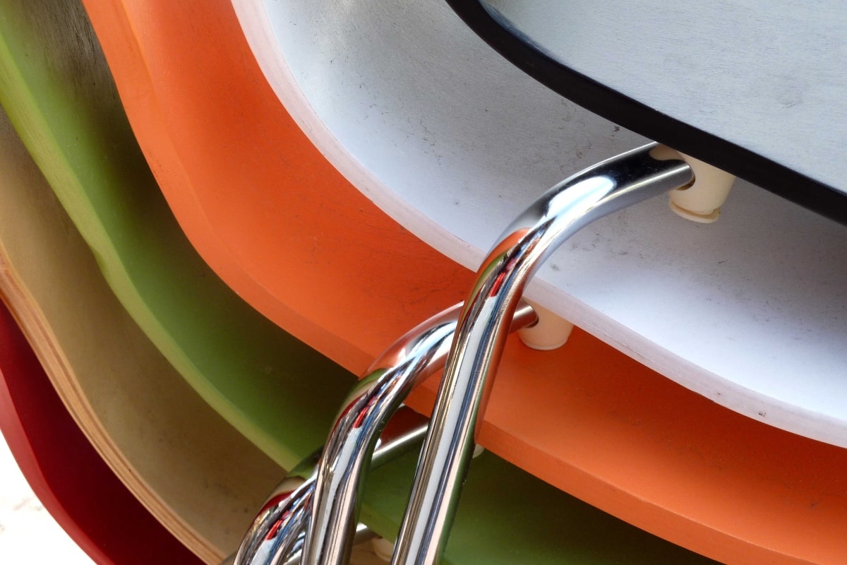 Close up of stacked chairs in multiple colours.
