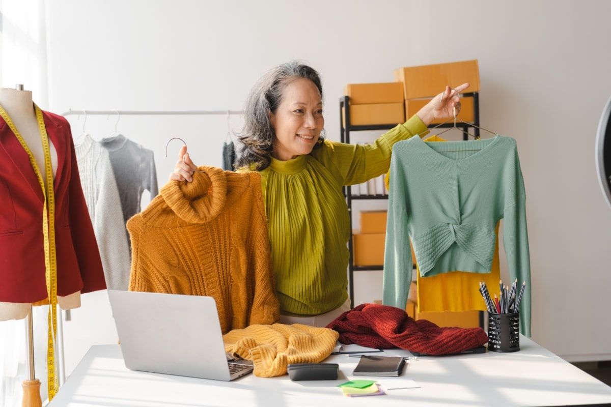 A creative home office idea for an online fashion shop, with woman holding up colourful clothes.