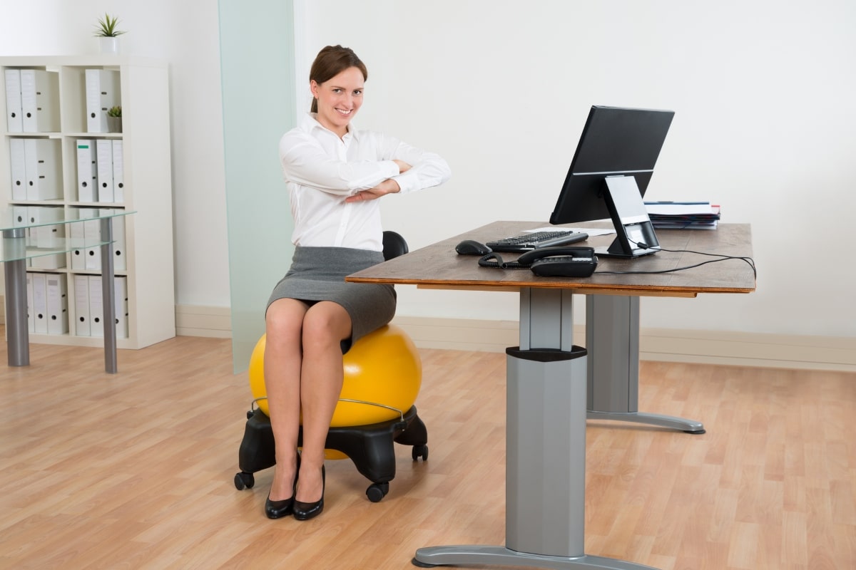 Improve your posture and ease lower back pain with seated spinal twists and other office chair exercises.