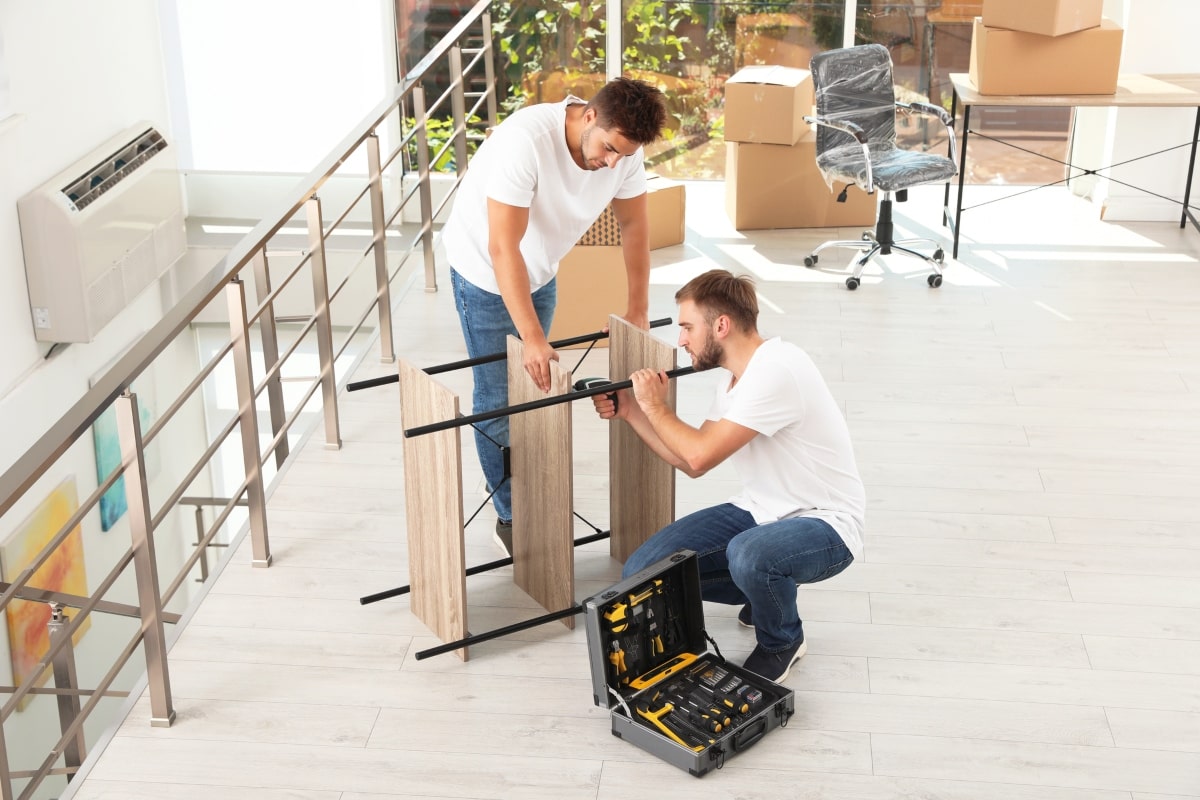Two workers assembling office furniture.